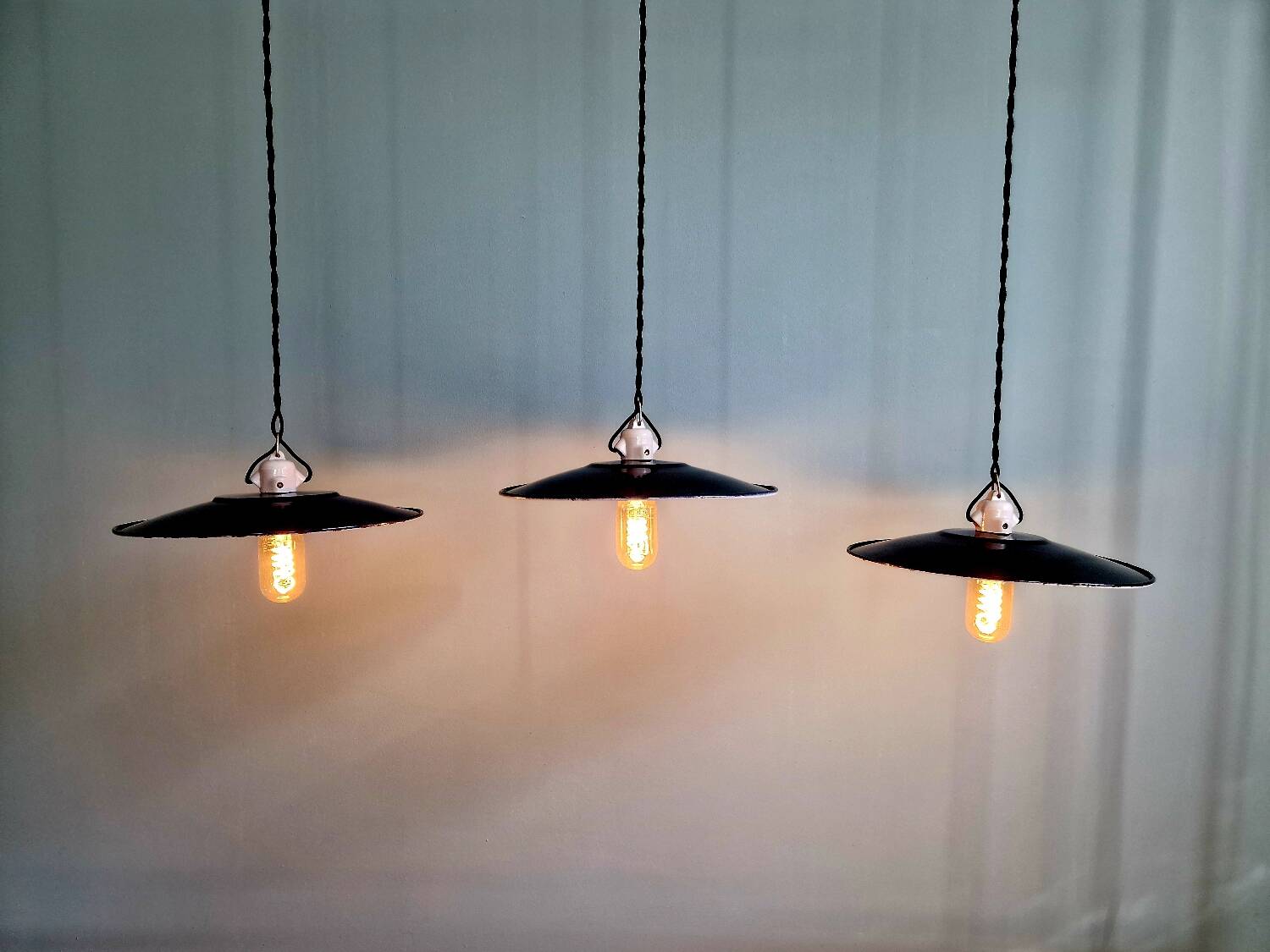 Three industrial suspensions in black enamelled sheet metal.
