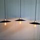 Three industrial suspensions in black enamelled sheet metal.
