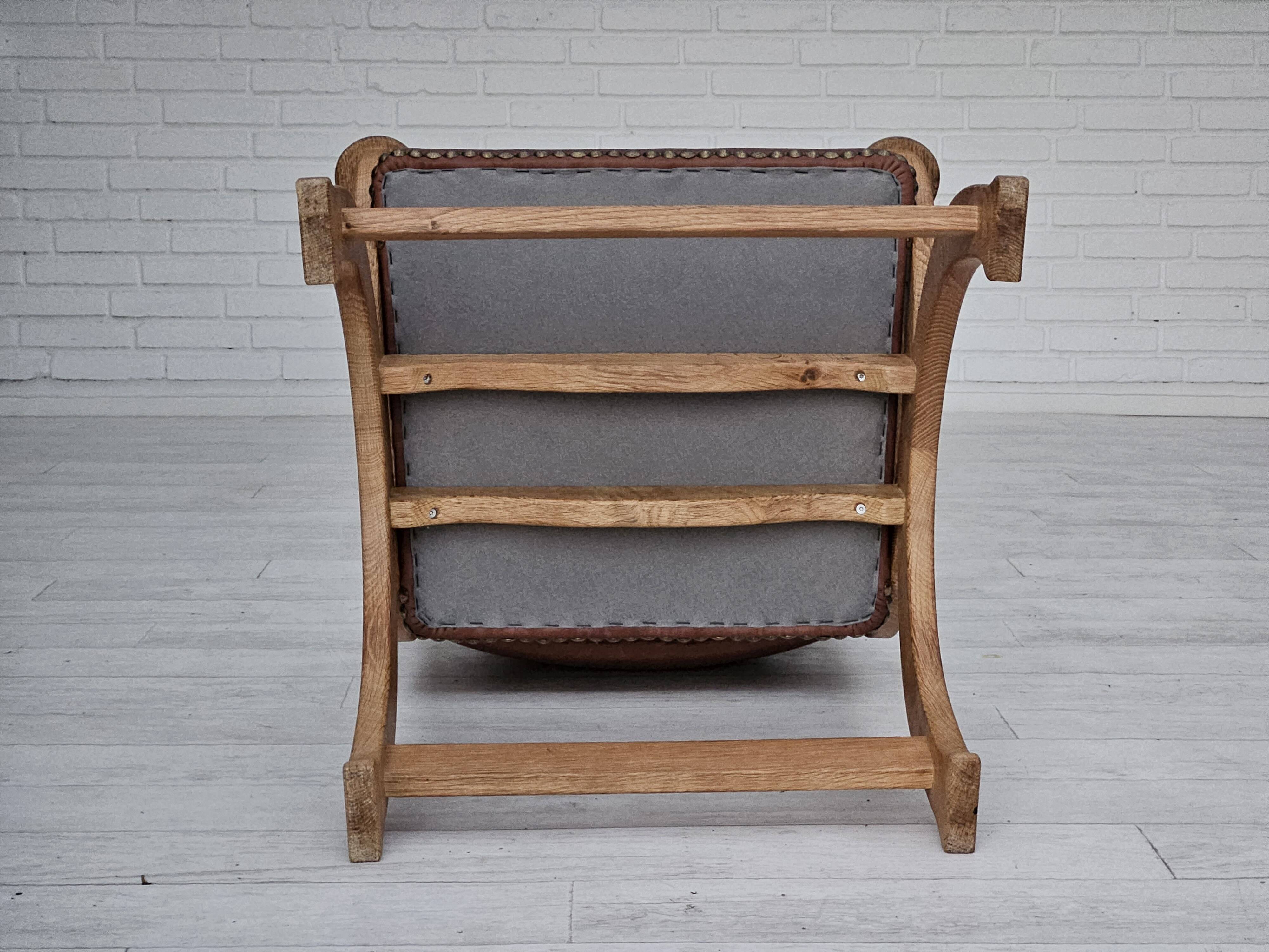 Années 1950, design danois, fauteuil retapissé, cuir marron naturel, bois de chêne.