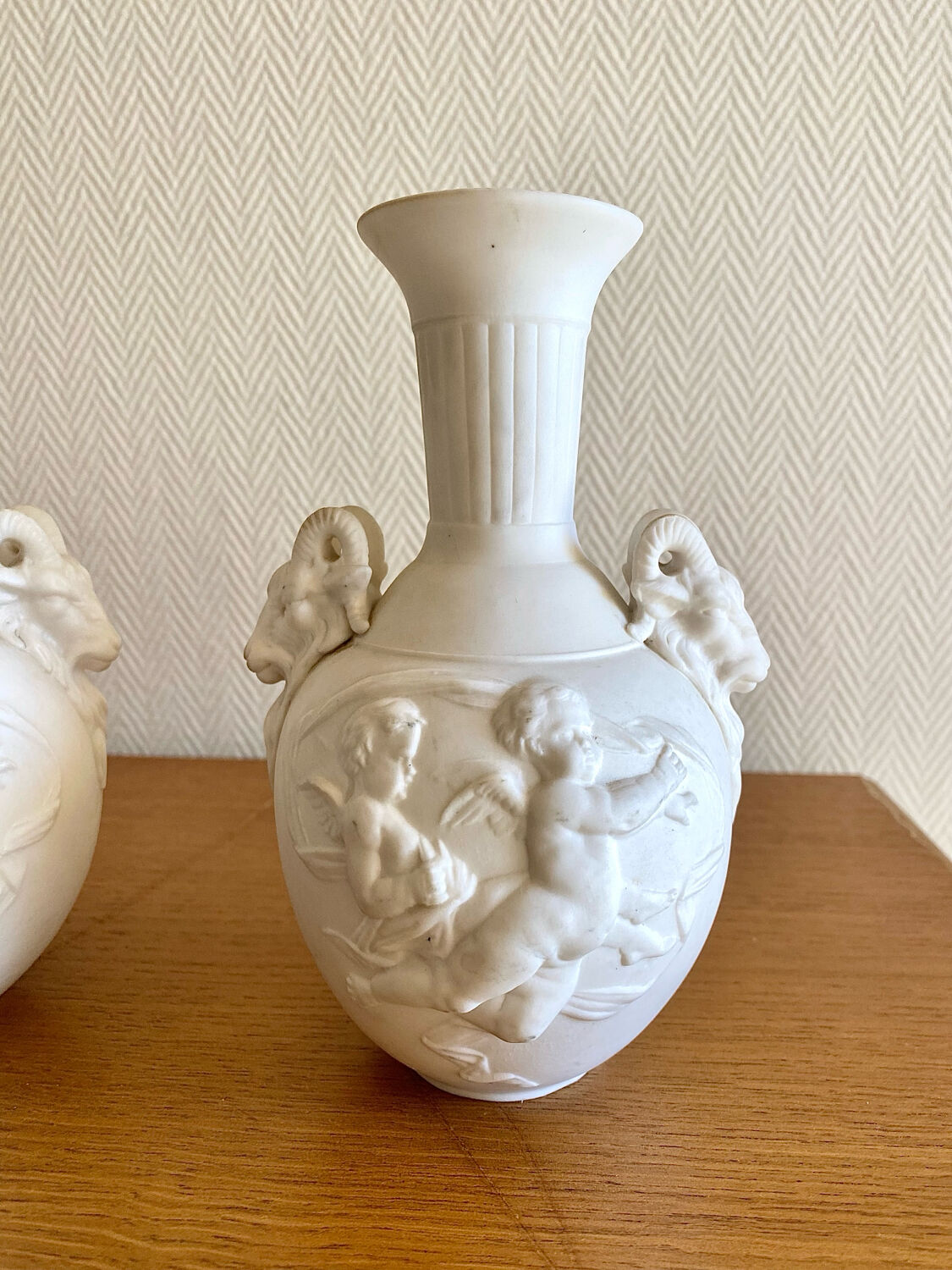 Paire de vases en biscuit decor putti et tête de bélier