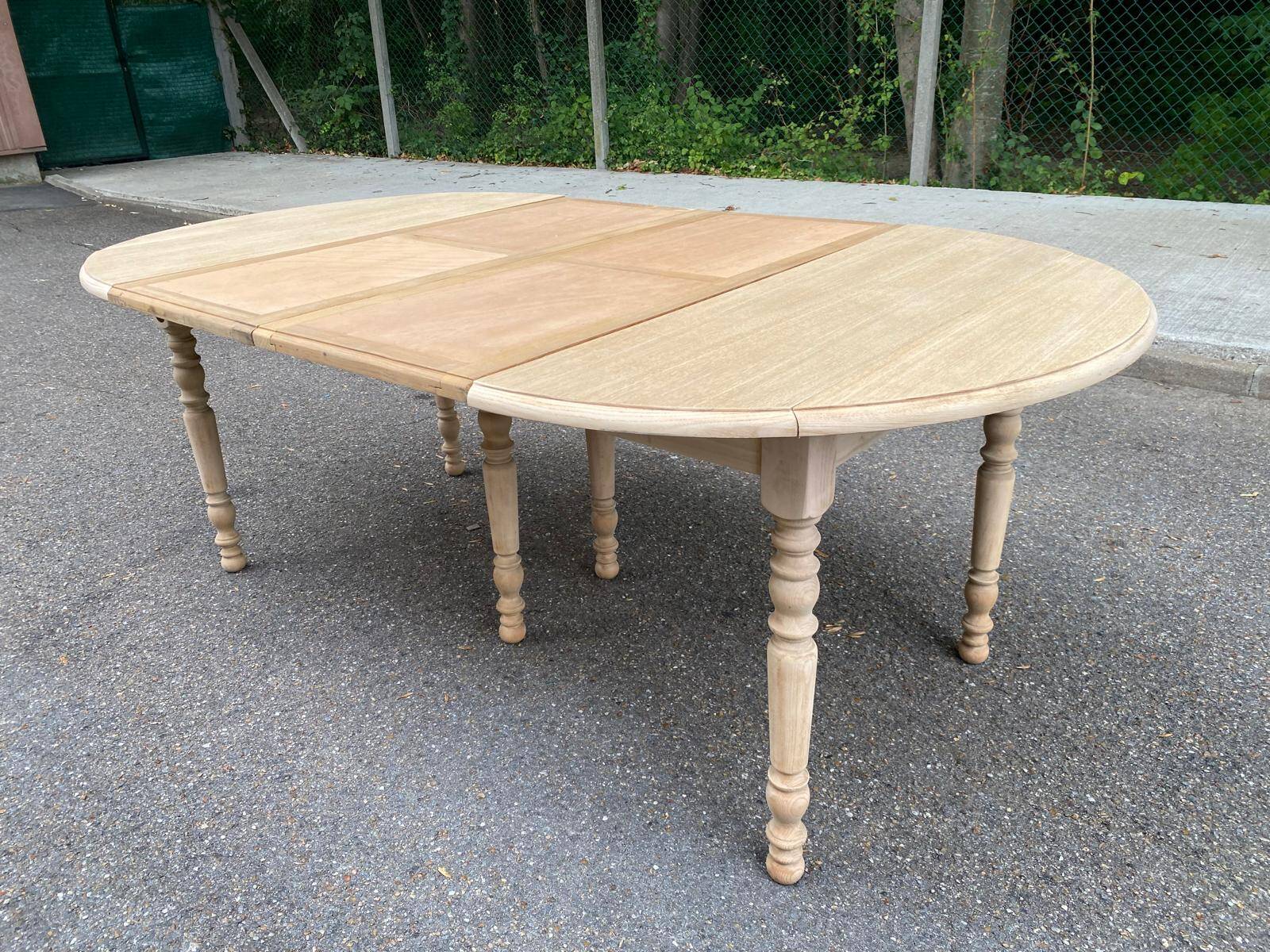 Round dining table with extendable leaves, Louis Philippe style, stripped in raw oak.