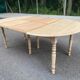 Round dining table with extendable leaves, Louis Philippe style, stripped in raw oak.