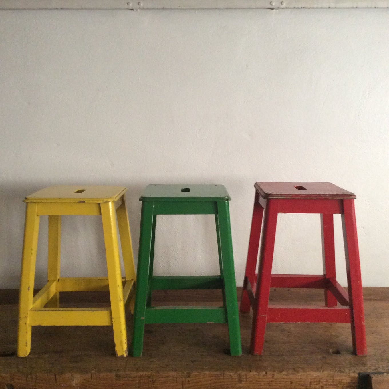 Three wooden stools with a handle
