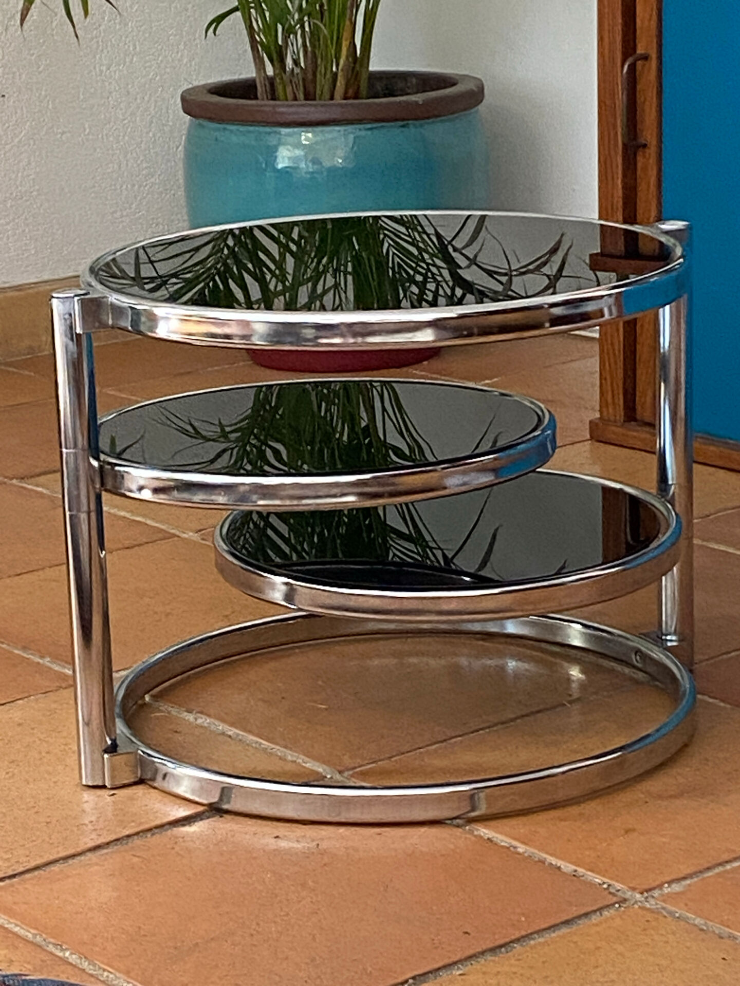 Coffee table with pivoting metal and black glass elements.