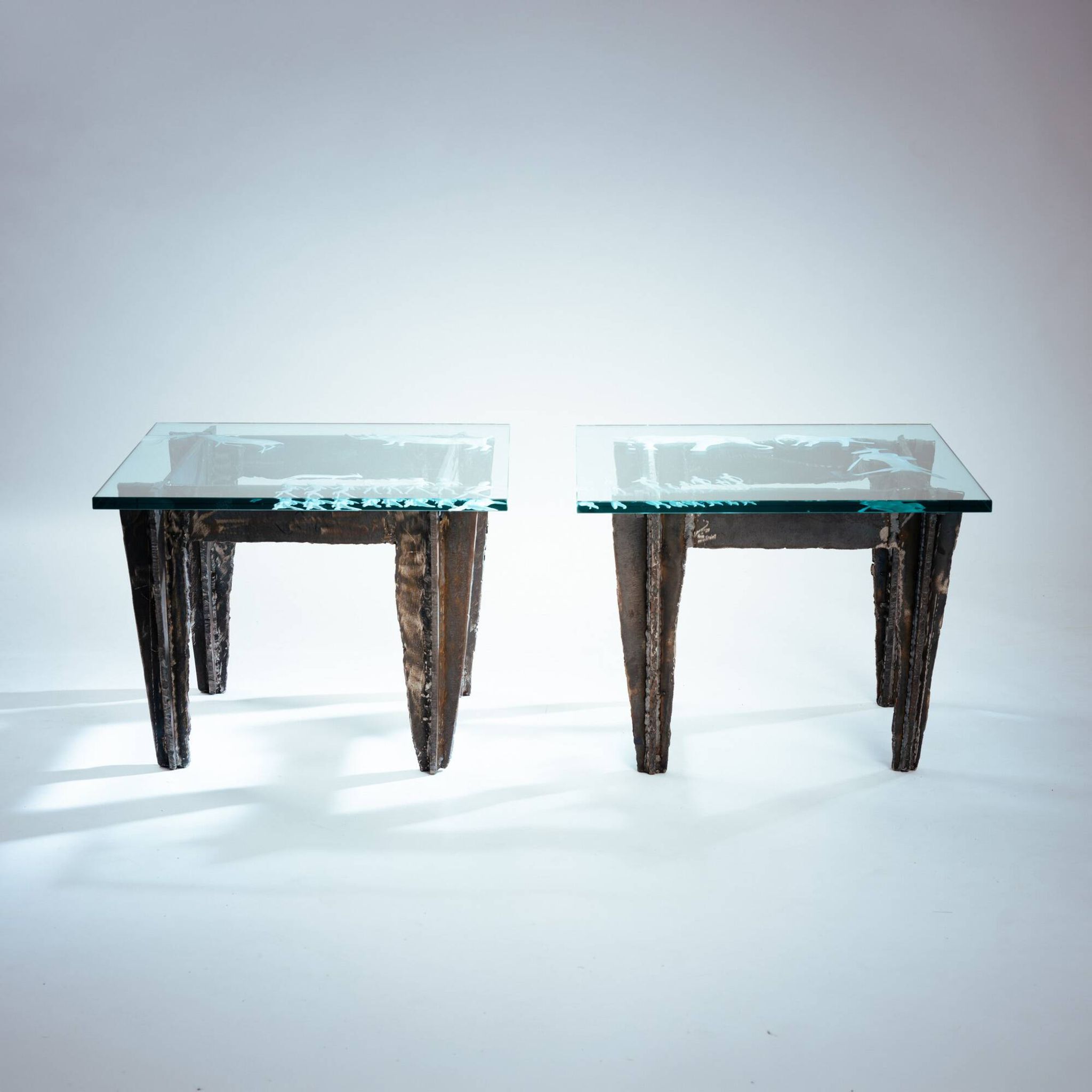 2 brutalist steel side tables with primitive  scene motifs etched glass