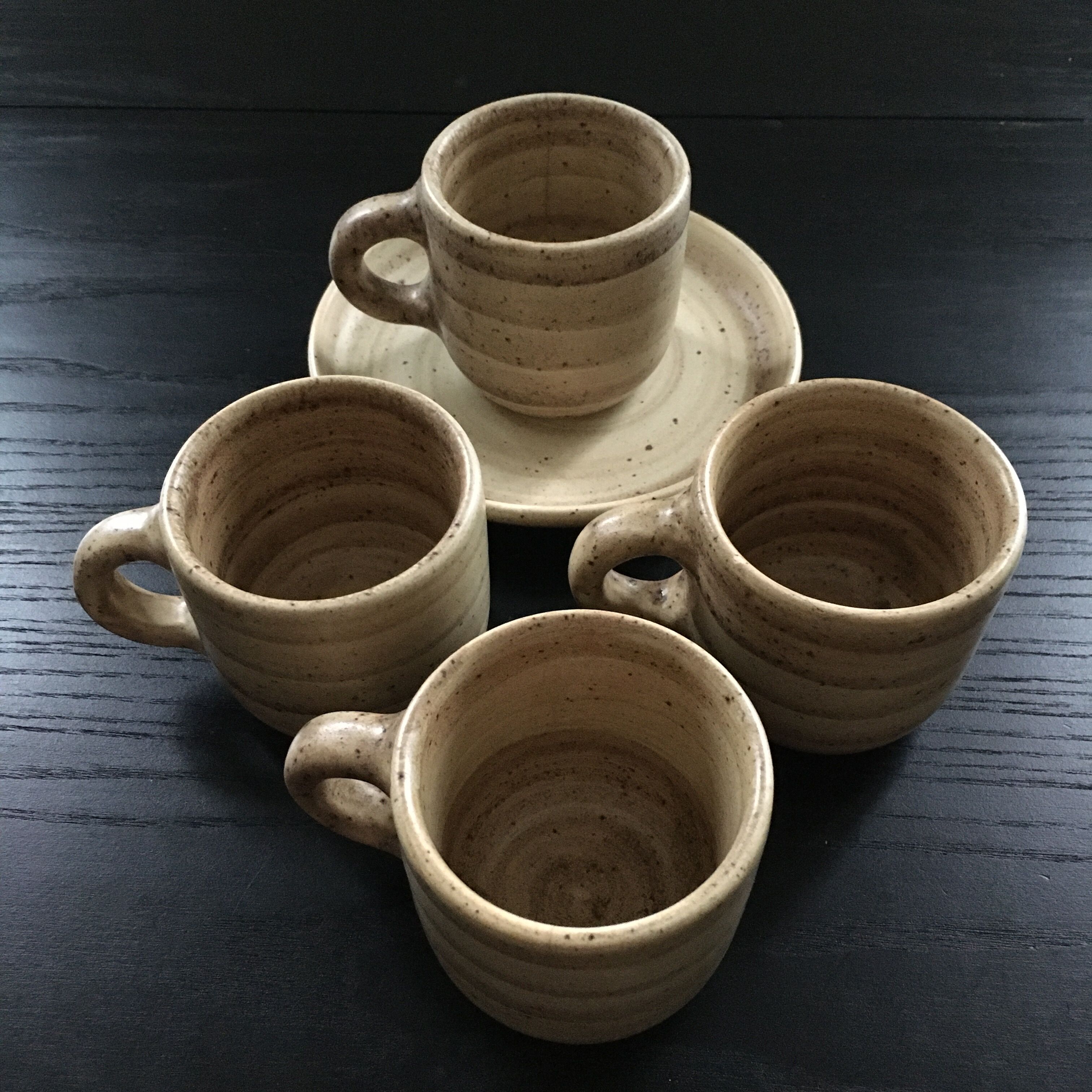 Set of 4 beige stoneware mugs.