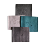 Set of four old damasked and monogrammed towels, tinted multiple colors