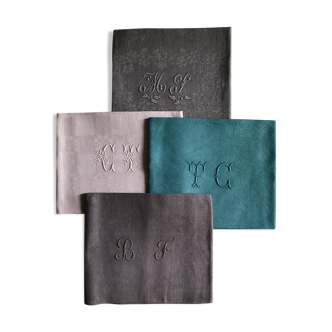 Set of four old damasked and monogrammed towels, tinted multiple colors