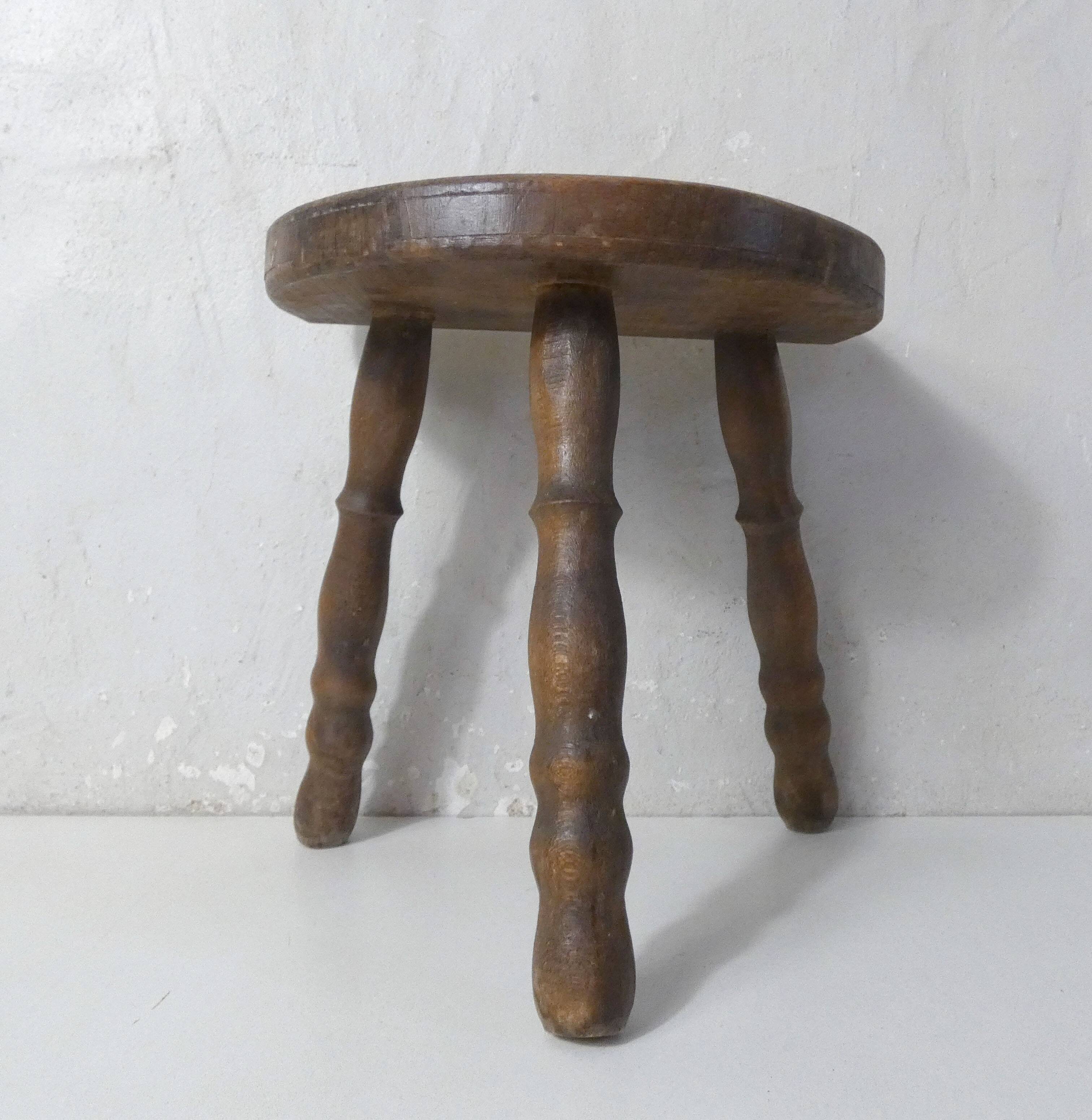 Old milking bench tripod stool in solid wood