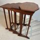 Four nesting tables with polygonal tops and decorative inlays.