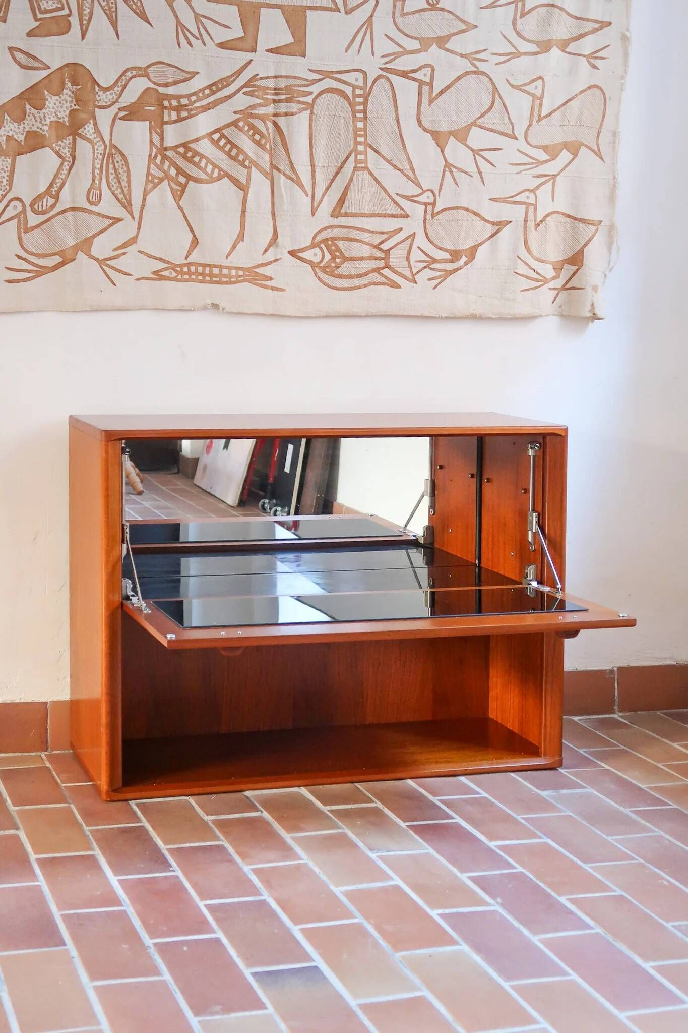 Vintage teak bar cabinet with black glass interior.
