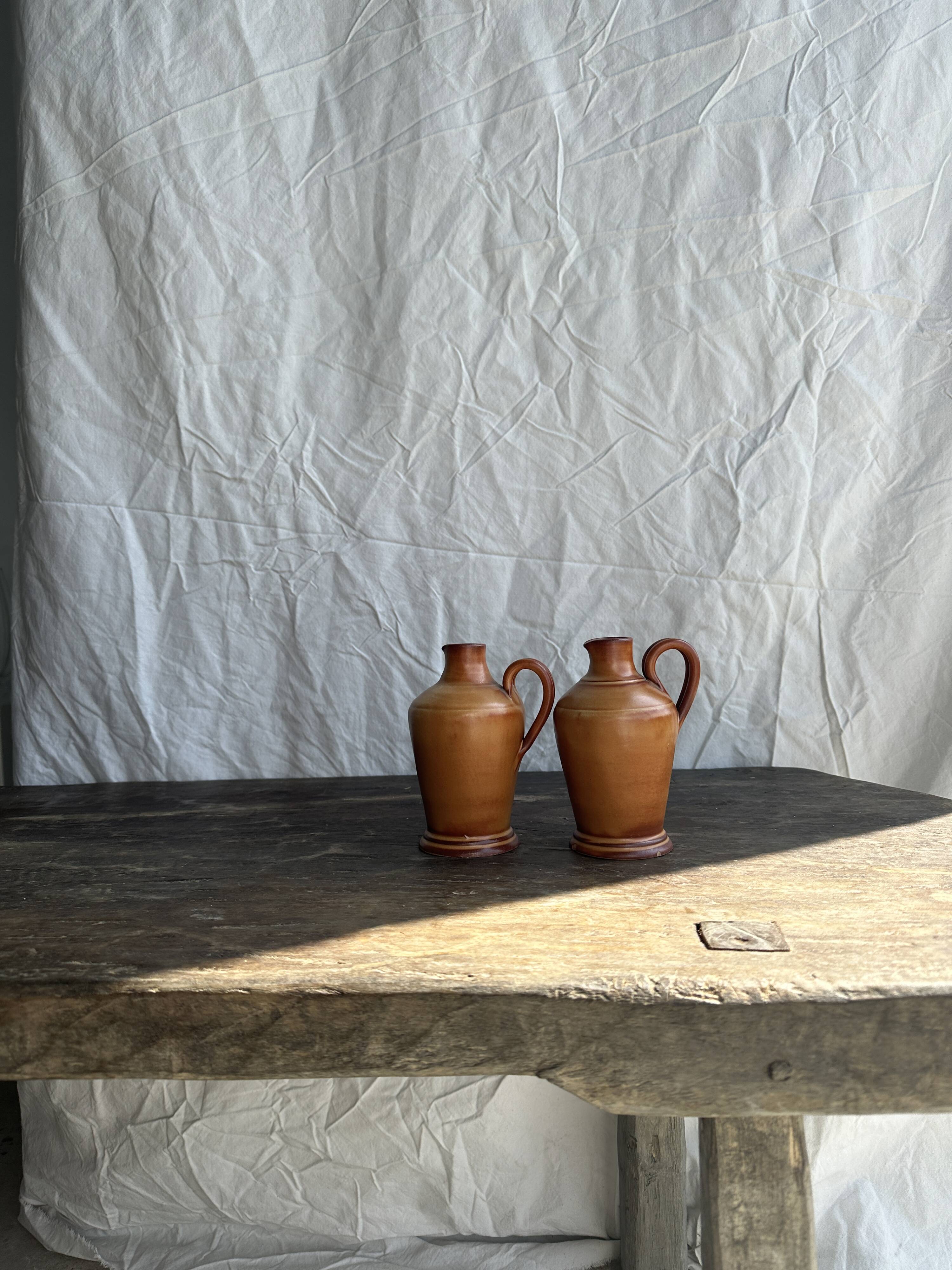 Pair of mini orange stoneware pitchers