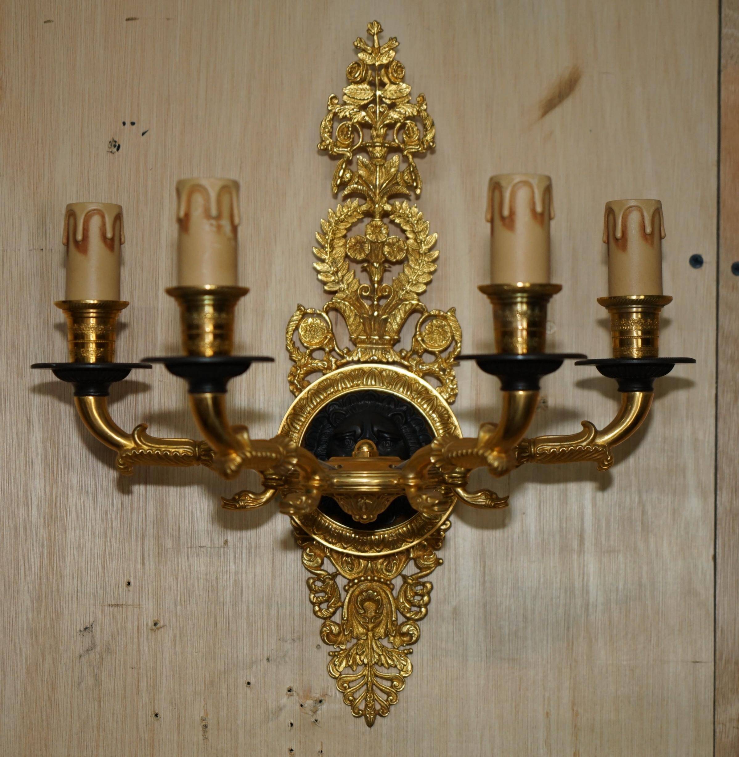 Pair of L'Originale wall sconces plated with 24-carat gold featuring four bronze candles.