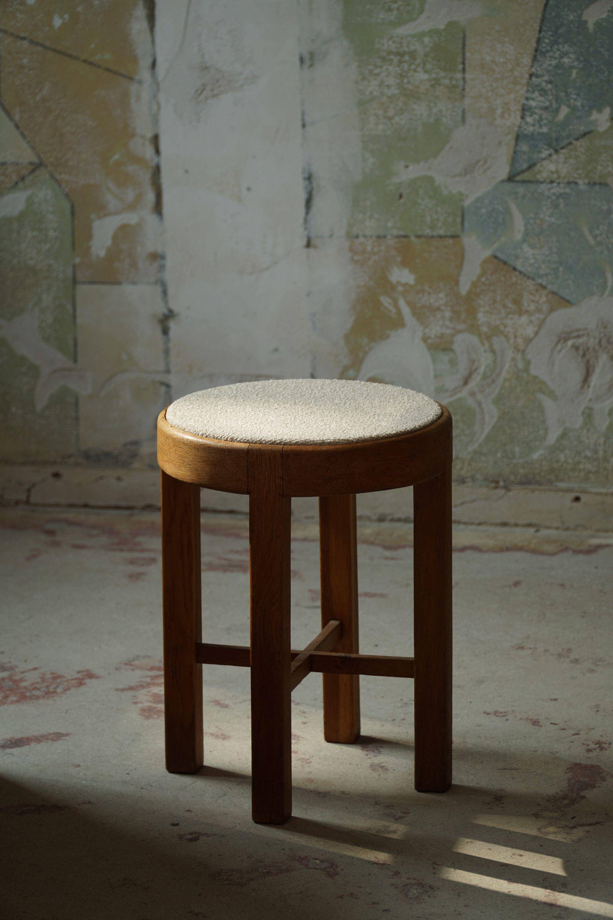 Mid-century Danish stool in oak, reupholstered in boucle wool, circa 1950.