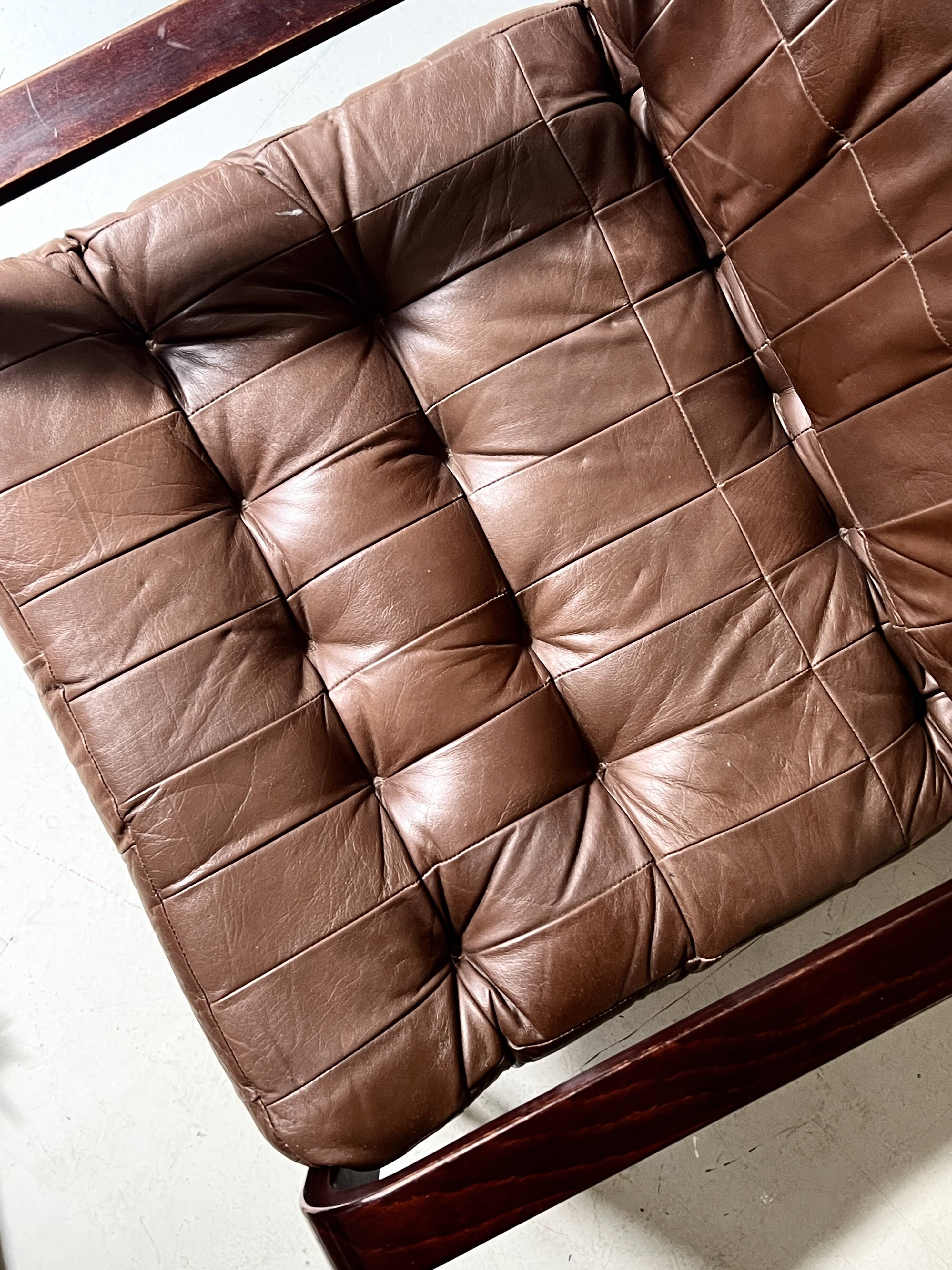 Scandinavian armchair with turned wood and brown patchwork leather, 70s design.