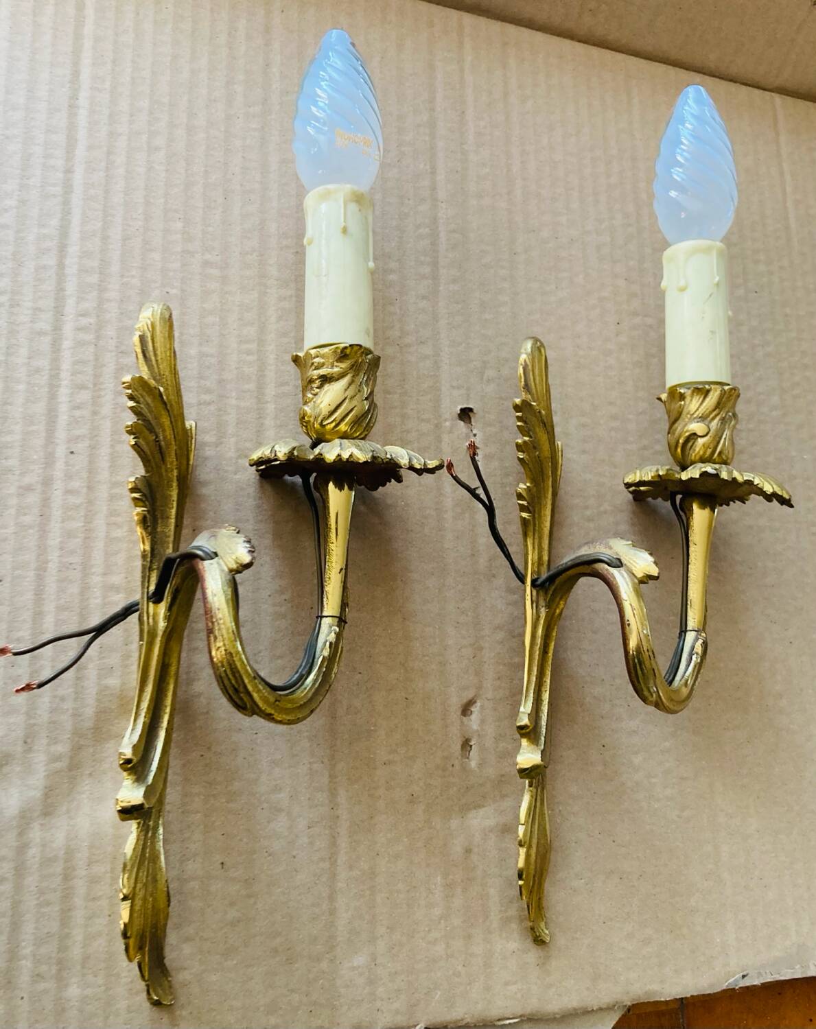 Bronze wall lights in the Louis XV style with curved branches and leaf decorations.