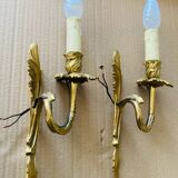 Bronze wall lights in the Louis XV style with curved branches and leaf decorations.
