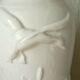 Thick white porcelain vase with relief decoration of a flying duck.
