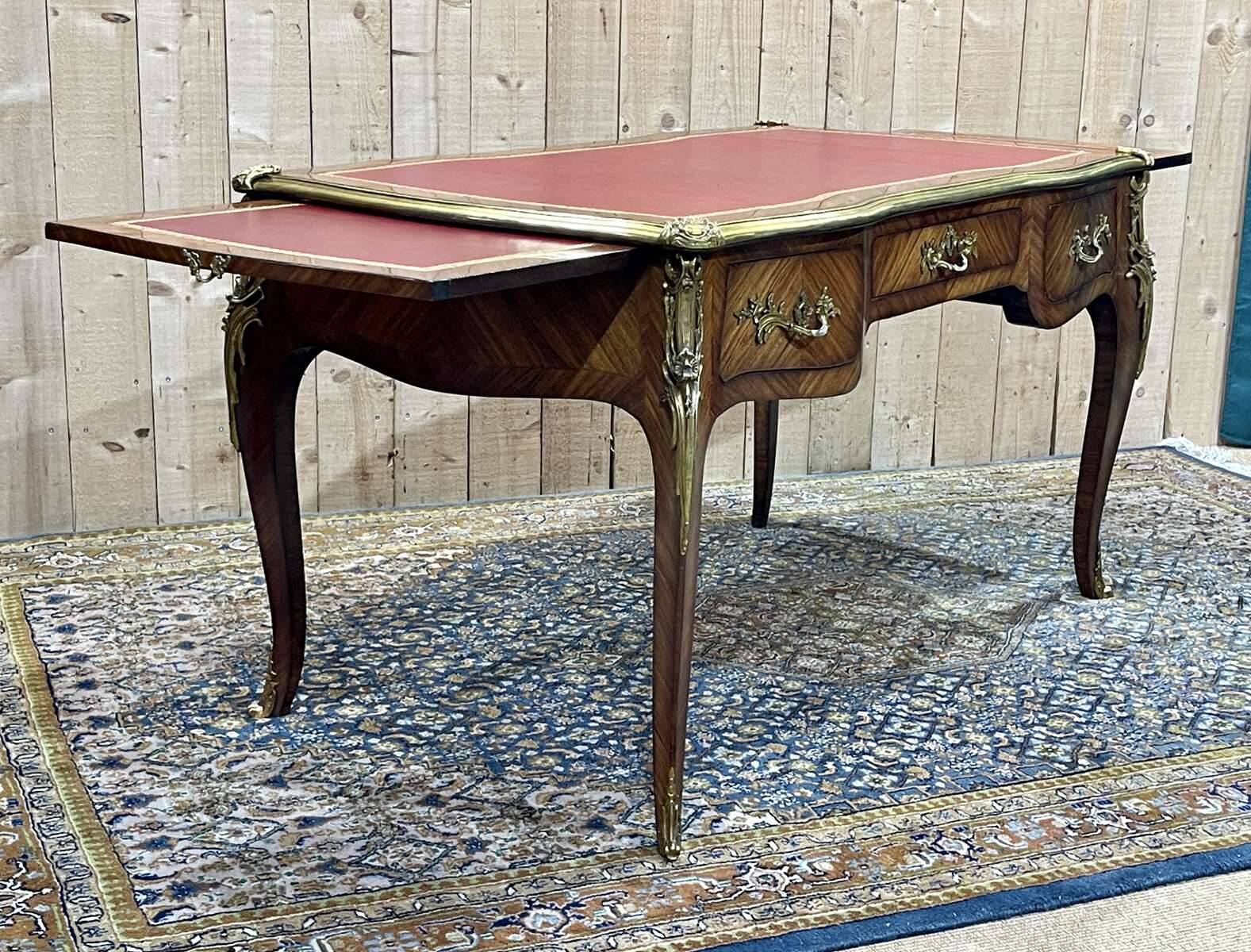 Bureau plat de style régence en placage de bois de rose, travail des années 1950