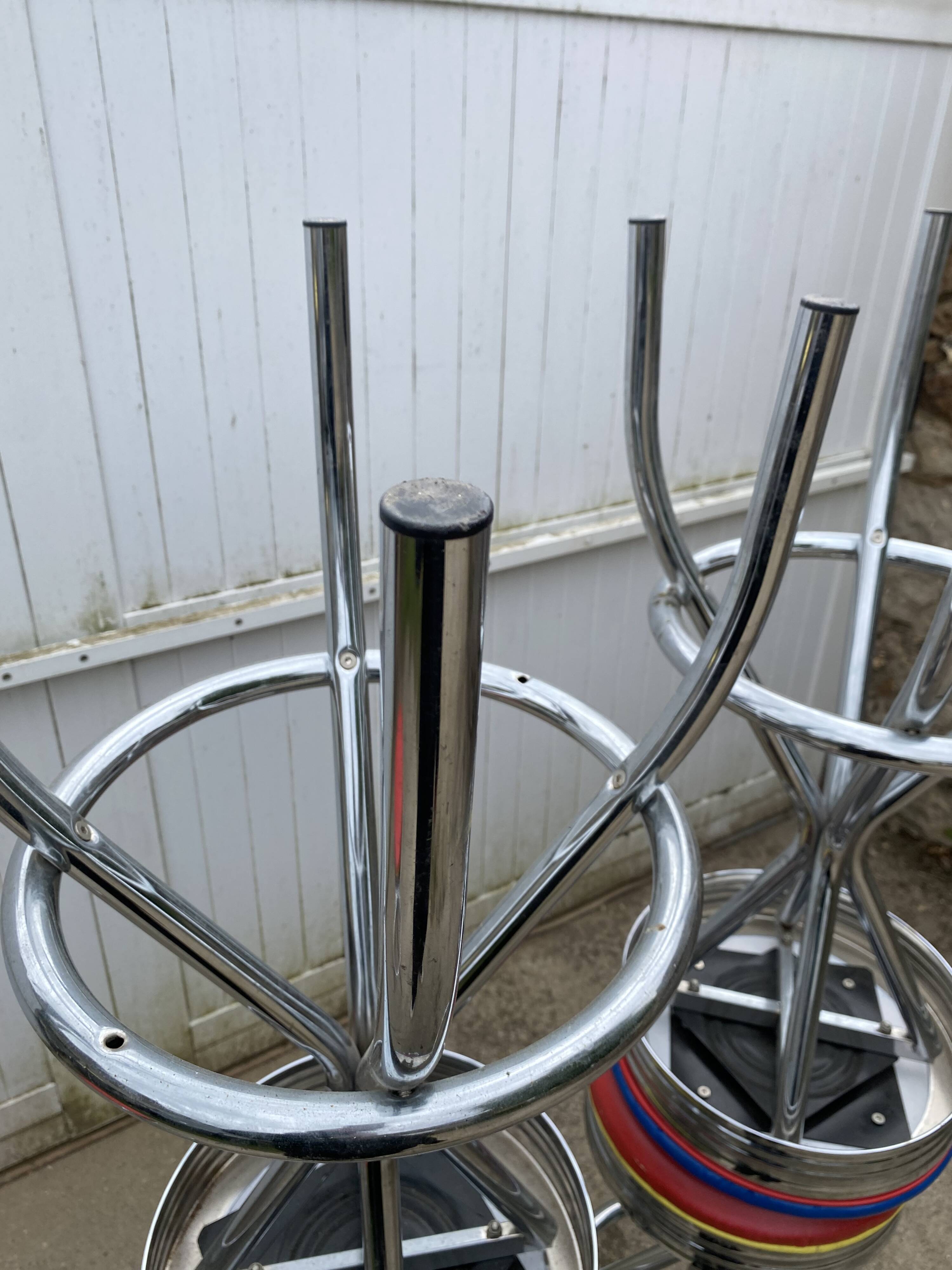 Set of 5 vintage swivel bar stools in blue, red, orange, and yellow.