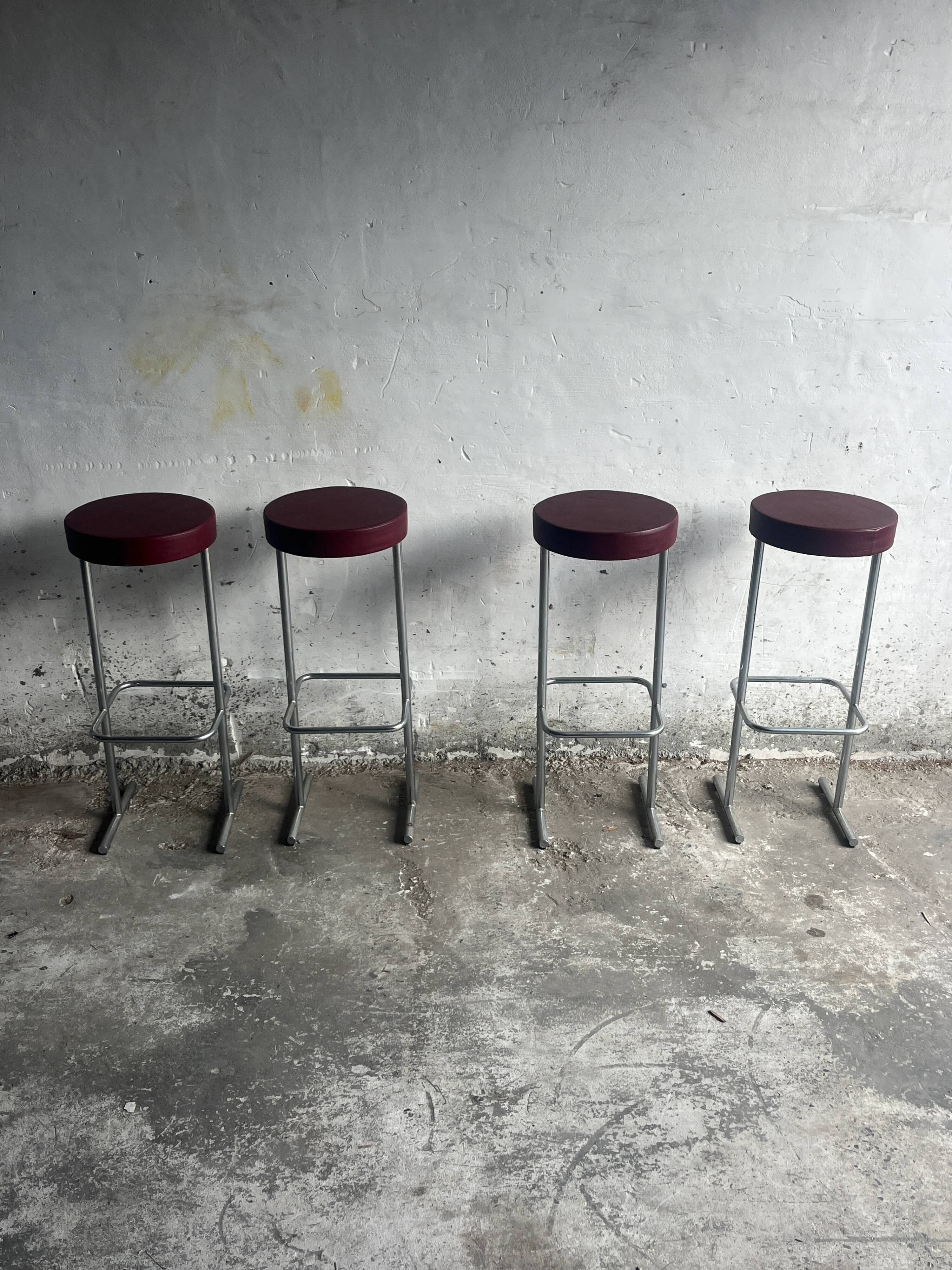 Ensemble de 4 tabourets de bar industriels – sièges bordeaux (années 1980)