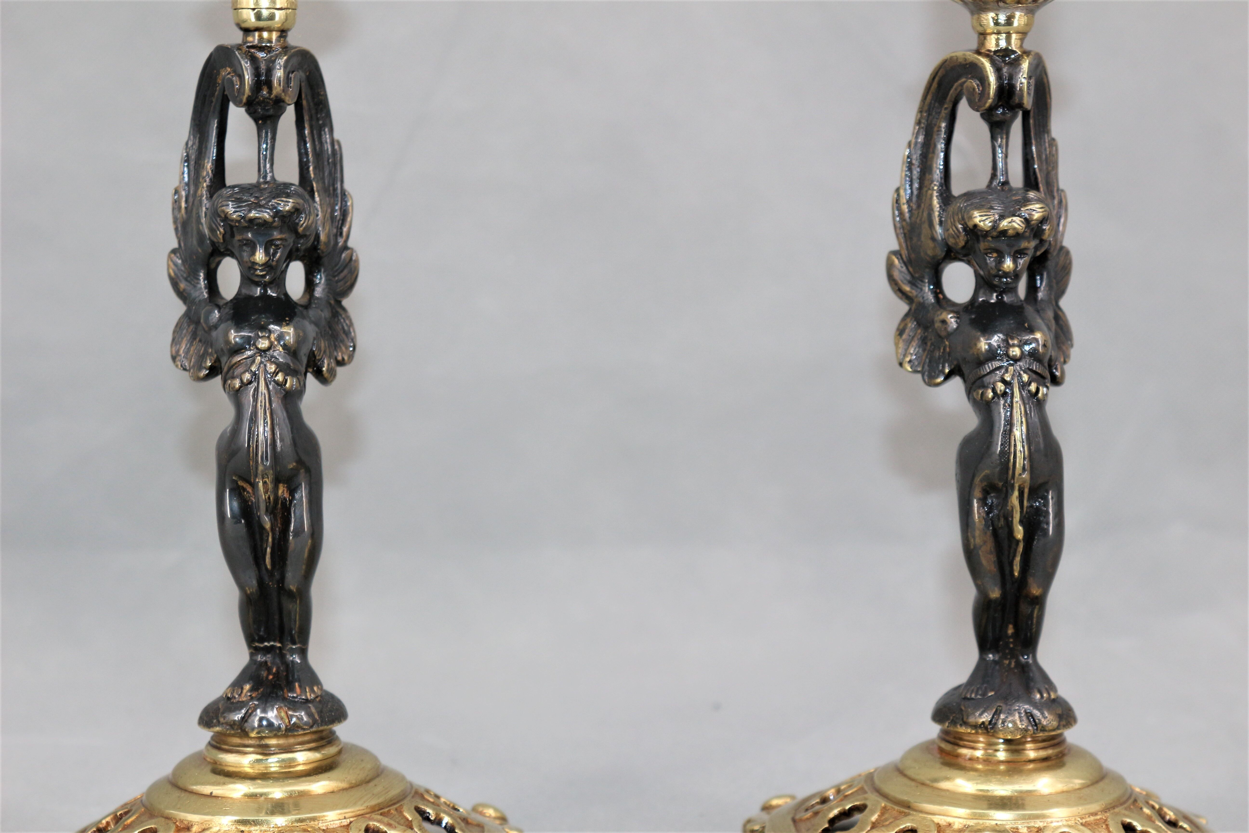 Pair of candle holders in gilded bronze and patinated with a candle