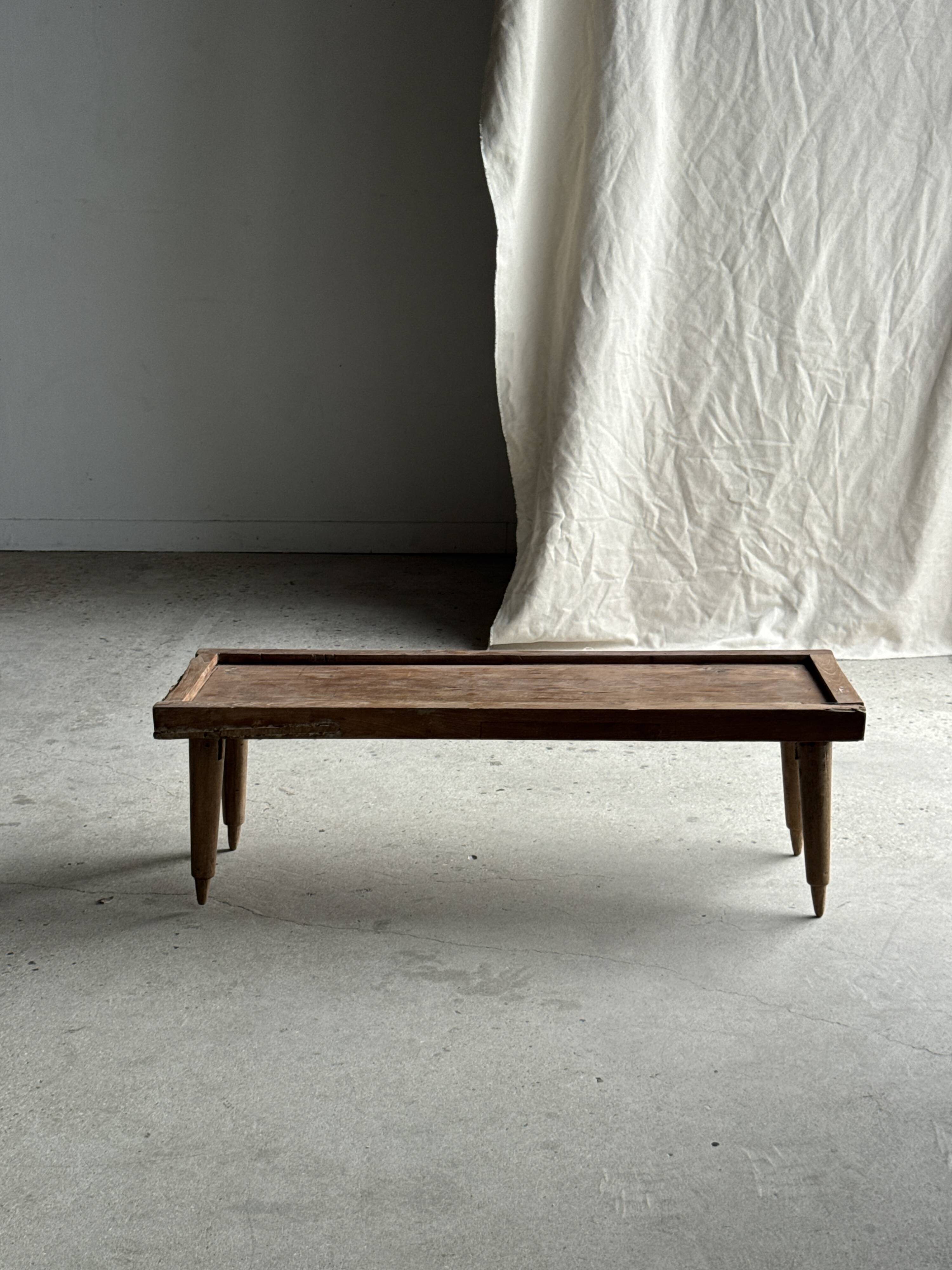 Brown Indonesian teak coffee table, with a border and cylindrical legs H40 L103.