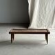 Brown Indonesian teak coffee table, with a border and cylindrical legs H40 L103.