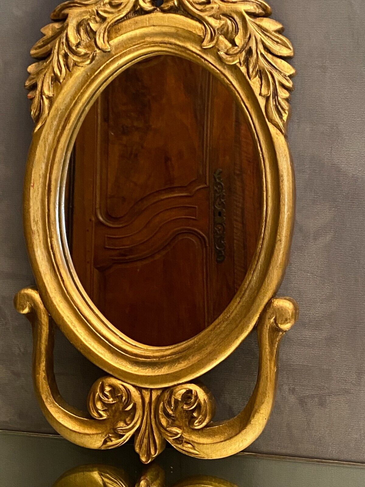 Oval view mirror in gilded wood with leafy decoration in Regency style