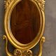 Oval view mirror in gilded wood with leafy decoration in Regency style