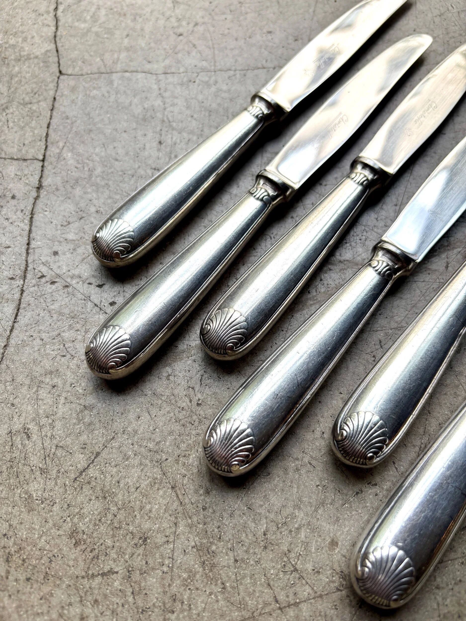 6 dessert knives by Christofle in silver-plated metal, shell decoration.