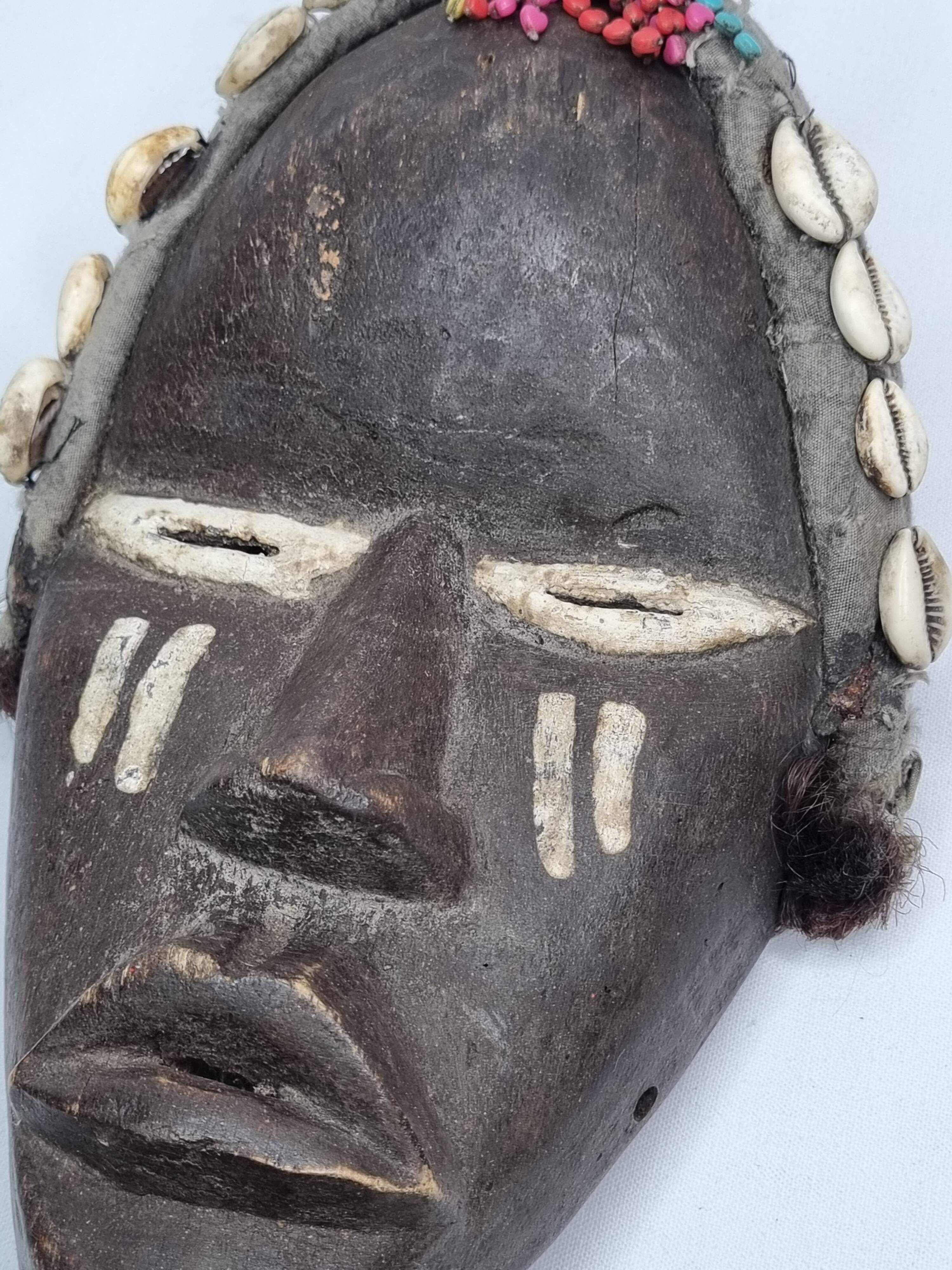 Tribal Dan mask in wood and cowrie shells, West Africa, 27 cm