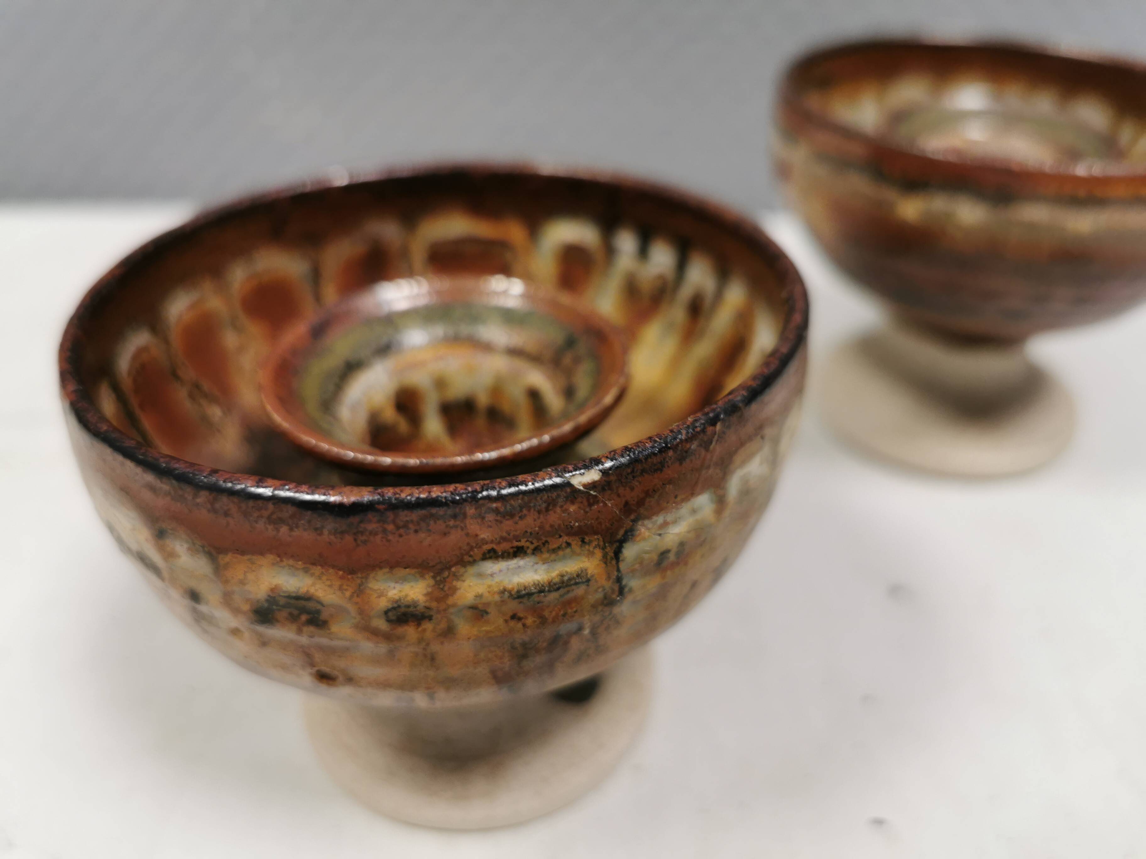 A set of ceramic candle holders in earthy colours.