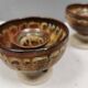 A set of ceramic candle holders in earthy colours.