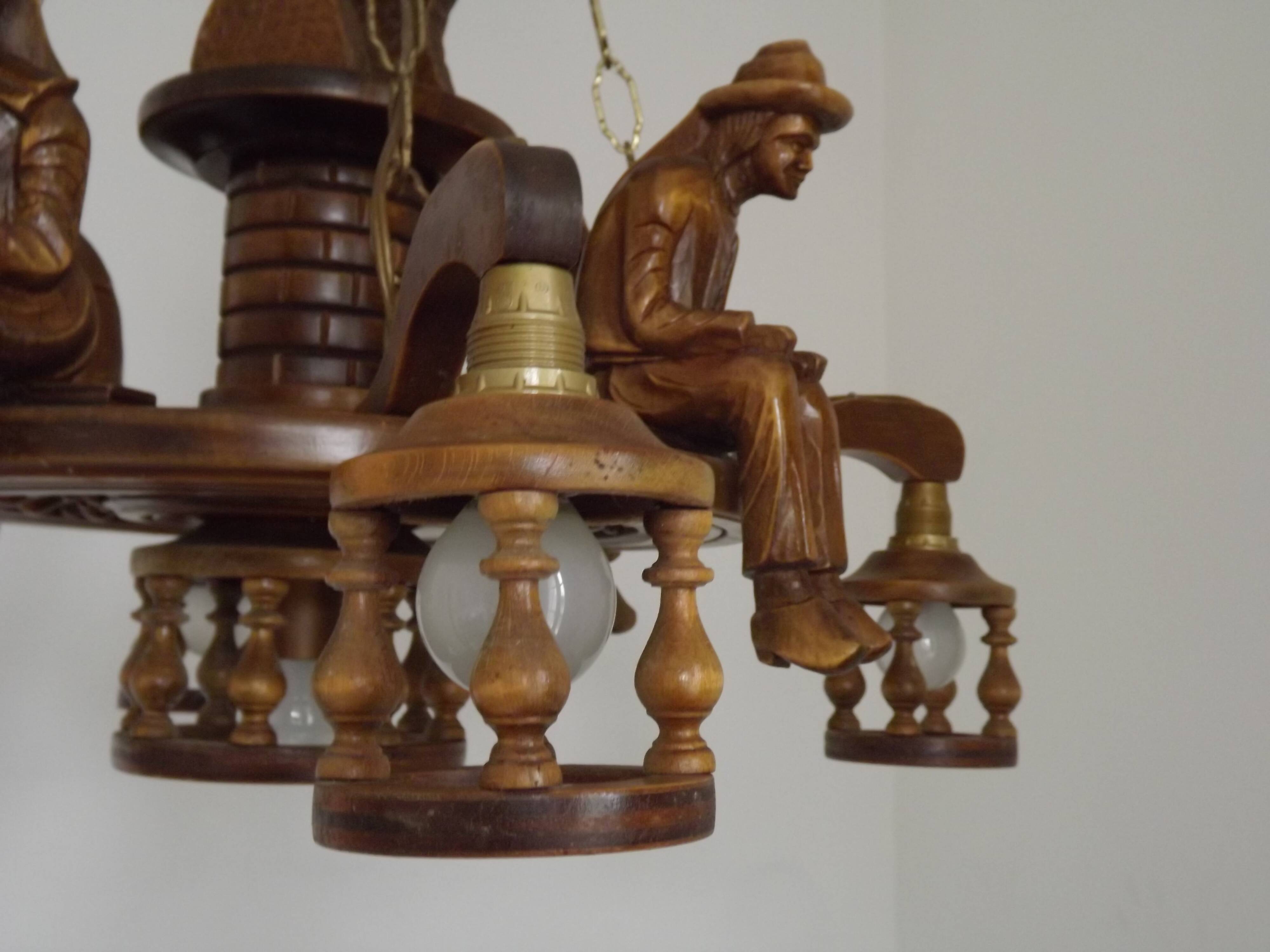 French vintage Breton chandelier with hand-carved figures, well, and lantern lights.