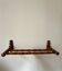 Wall-mounted coat rack made of turned wood in a bamboo style.