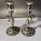 Two silver-plated metal candlesticks decorated with cherubs, 20th century