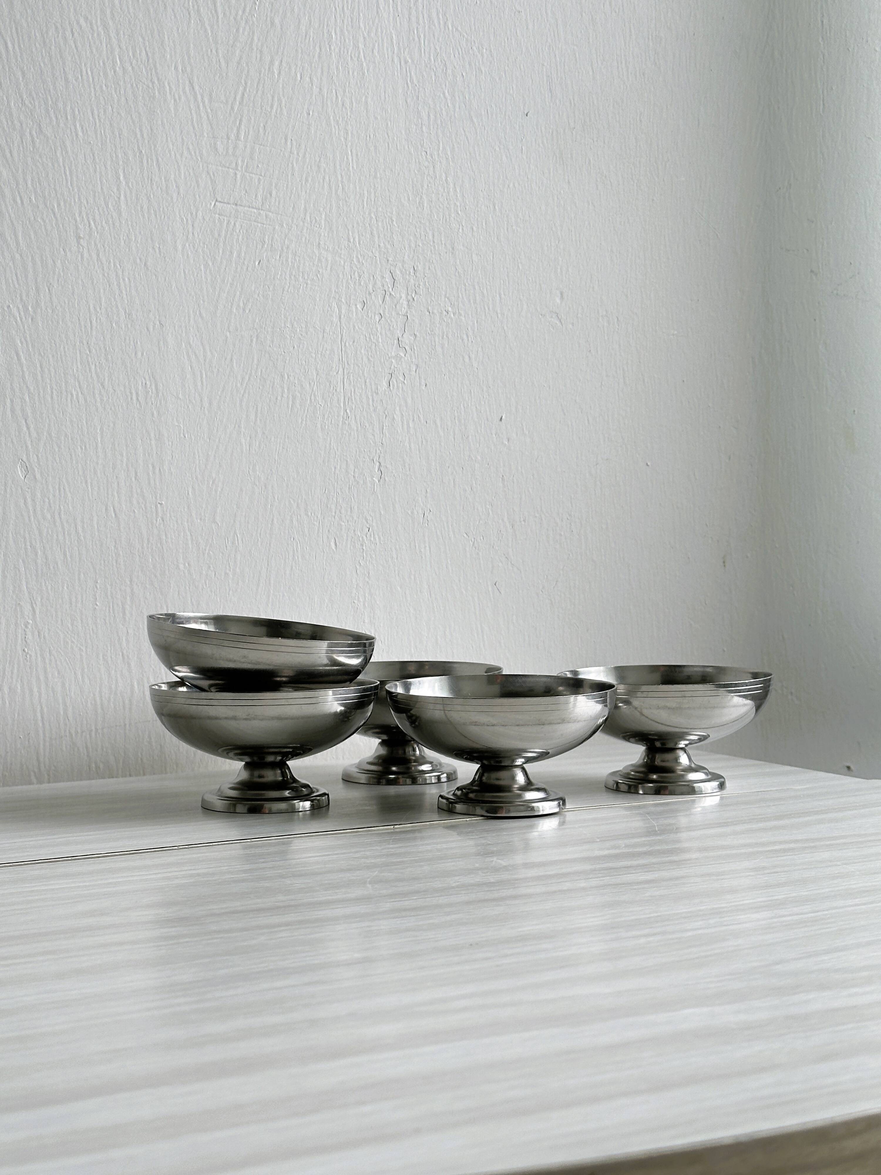 5 silver metal cups.