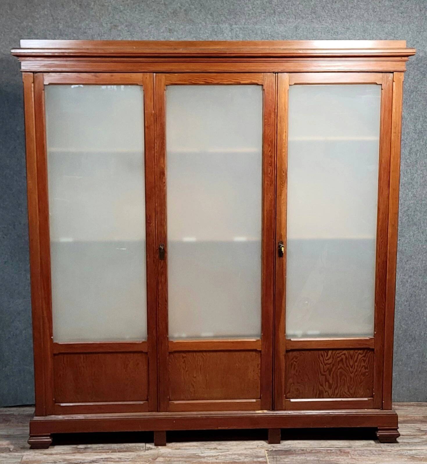 Large pine bookcase with three doors, fitted with frosted glass.