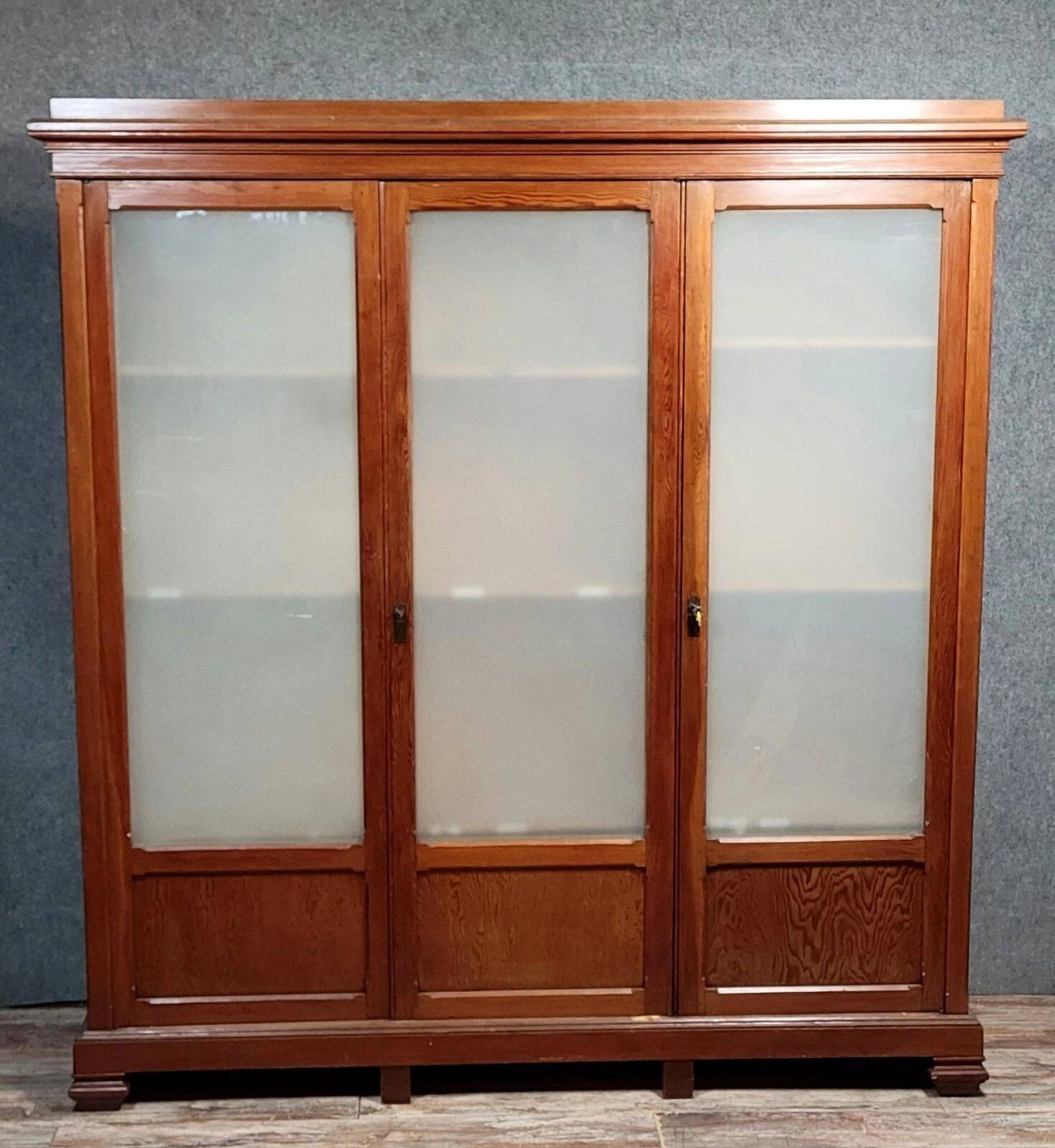 Large pine bookcase with three doors, fitted with frosted glass.