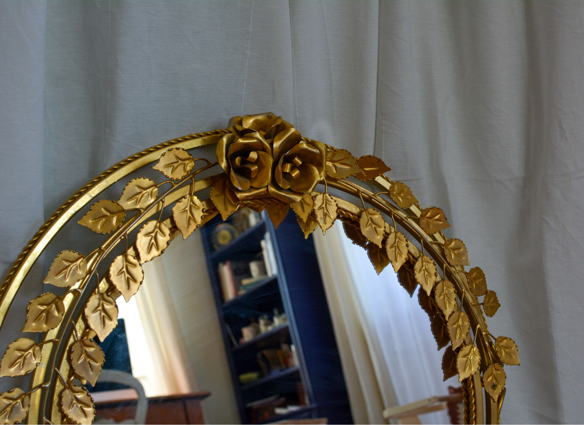 Vintage round illuminated mirror in gold metal with rose decoration.