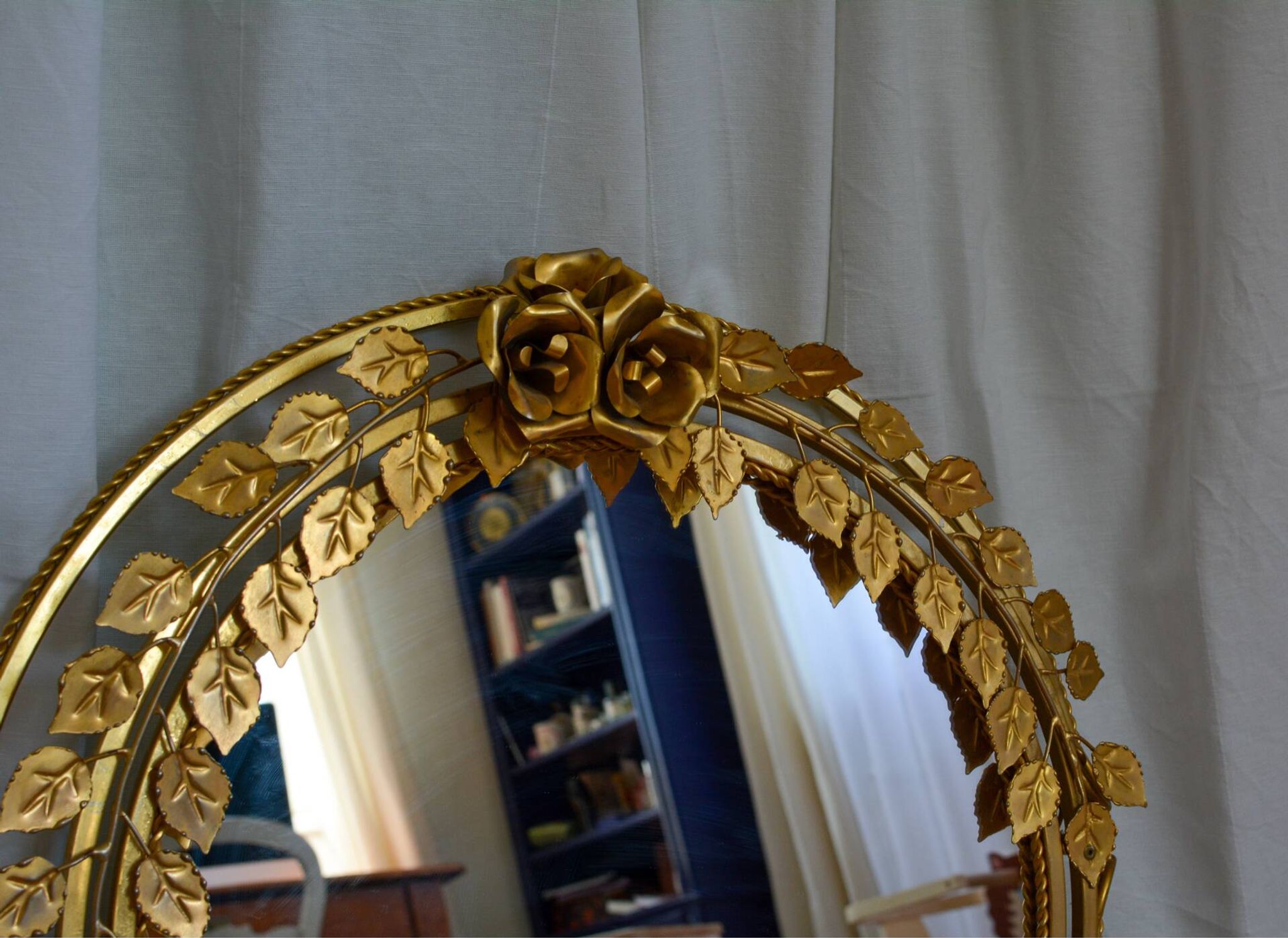 Vintage round illuminated mirror in gold metal with rose decoration.