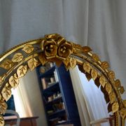Vintage round illuminated mirror in gold metal with rose decoration.