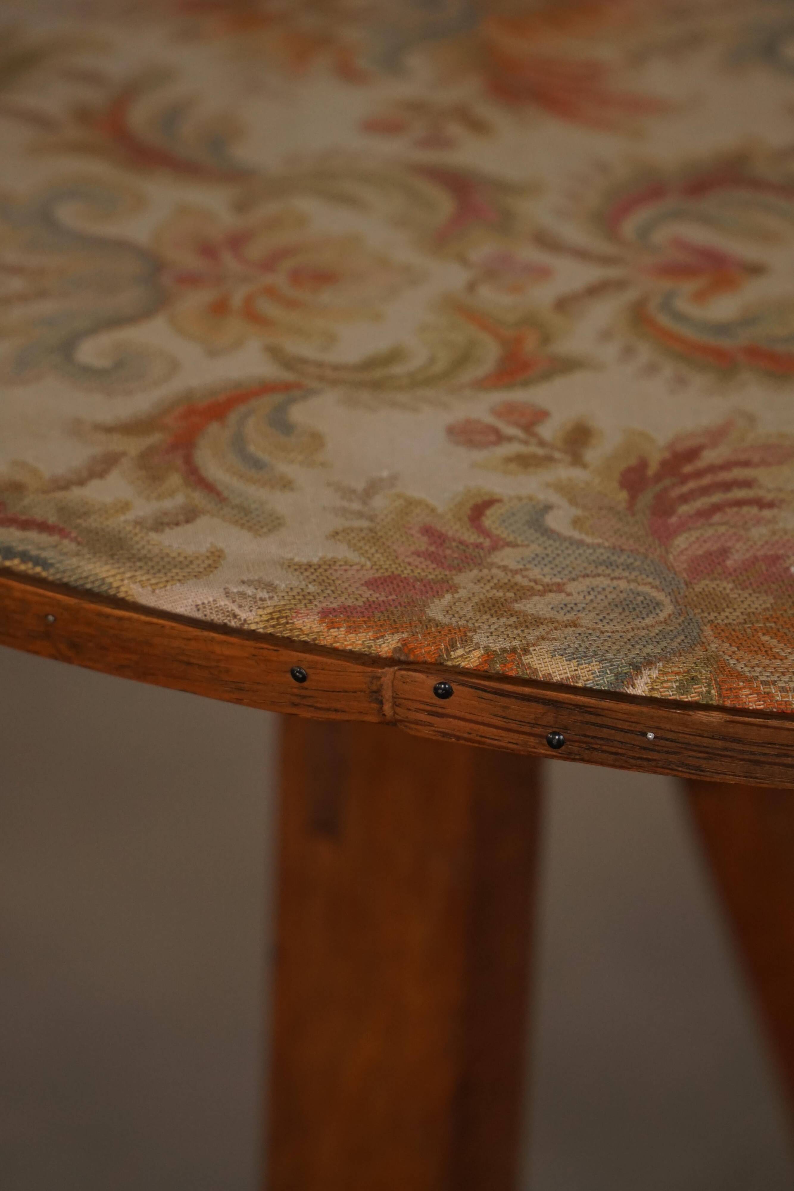 19th-century French round wine table with an adjustable top and floral textile surface.