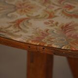 19th-century French round wine table with an adjustable top and floral textile surface.