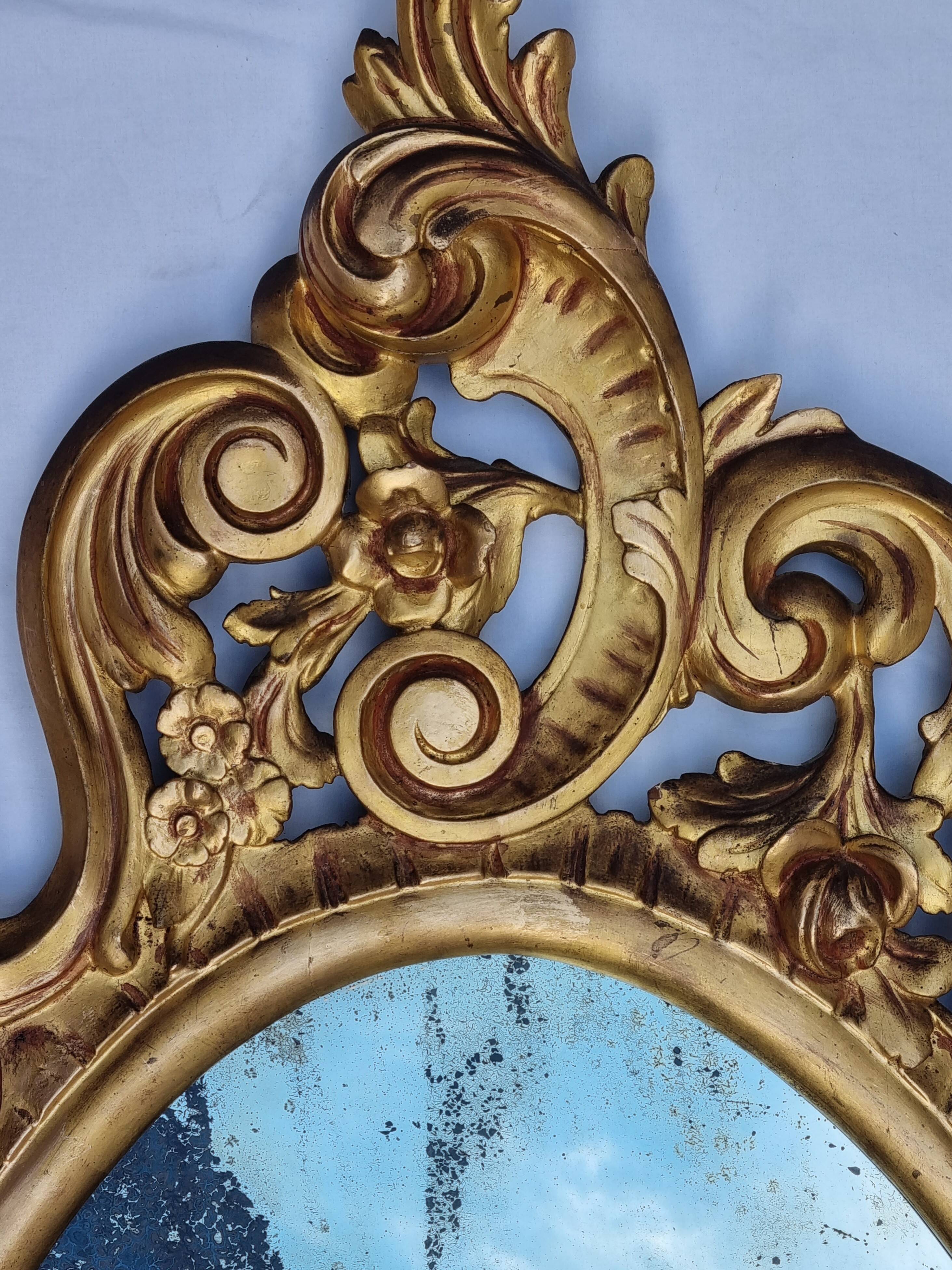 Large oval gold mirror, Louis XV rococo style, late 19th century, 114 x 66 cm.