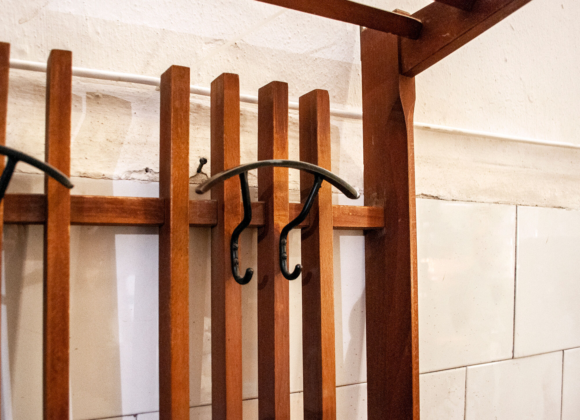 Walnut wood wall coat hangers, with metal details. Italian production 1950s
