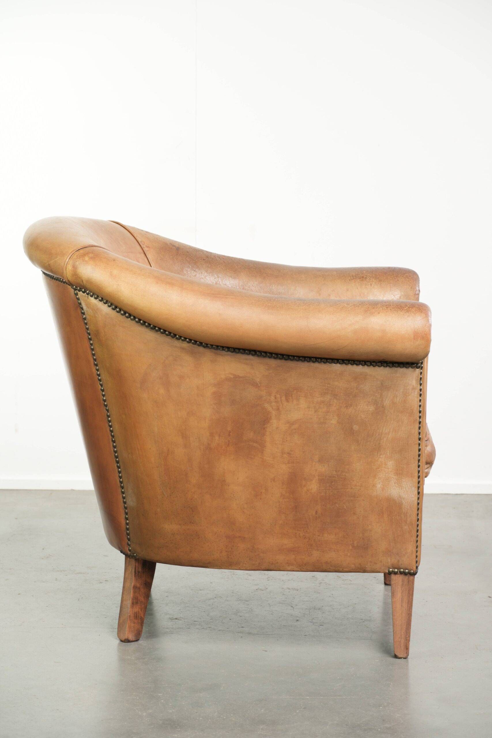 Fauteuil club en peau de mouton confortable de couleur cognac.