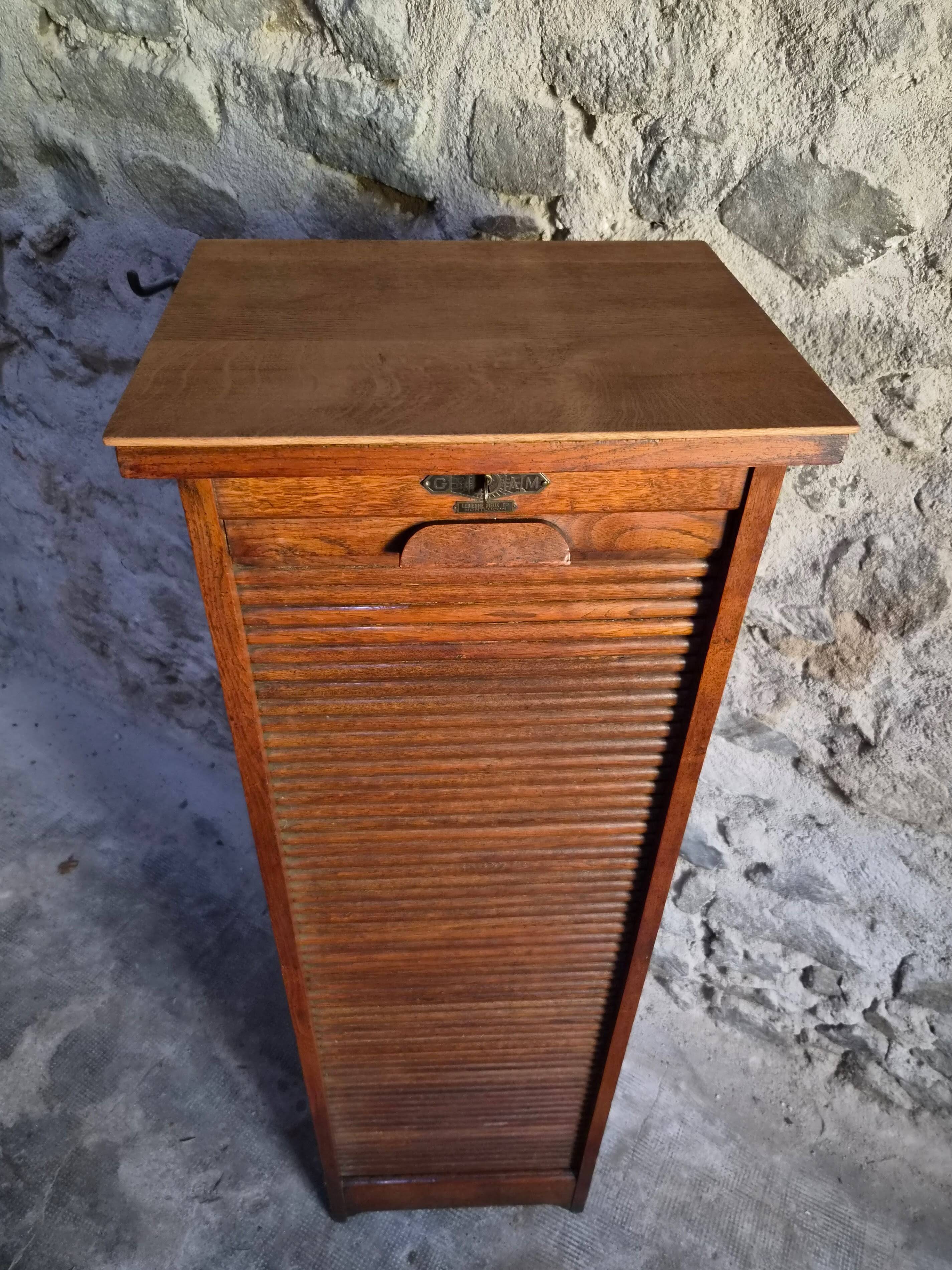 French antique wardrobe with curtain in oak, circa 1920–1930.