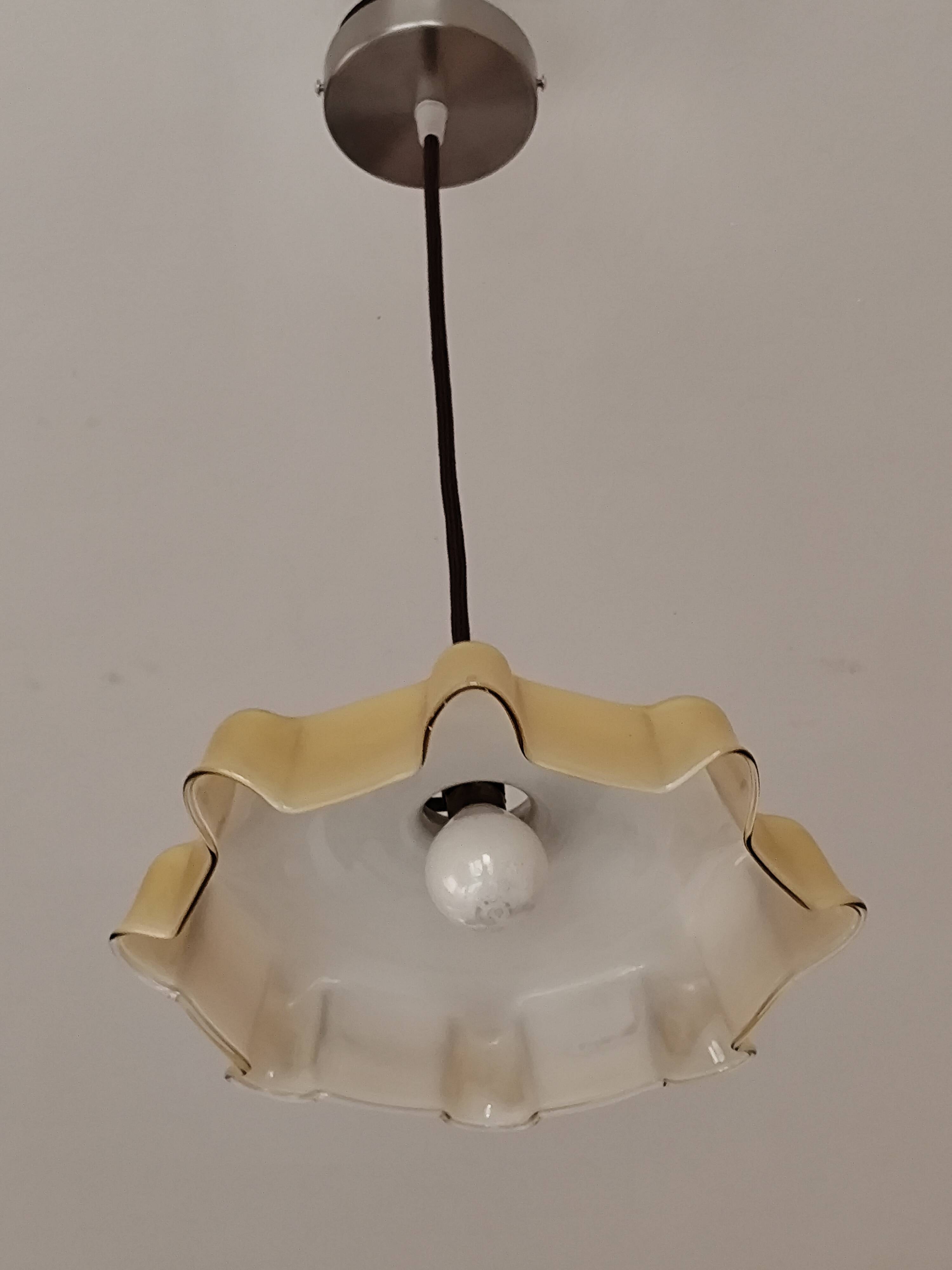 Electrified suspension with a frosted opaque glass disc shade.